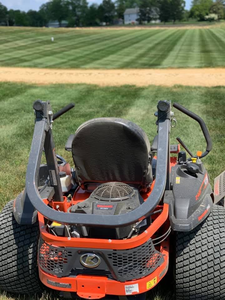 Ride-on mower parked on a neatly striped lawn