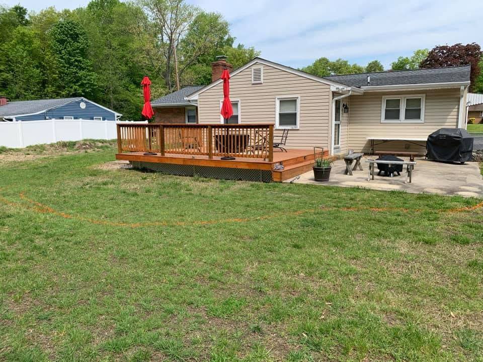 Green backyard lawn beside a timber deck with red umbrellas